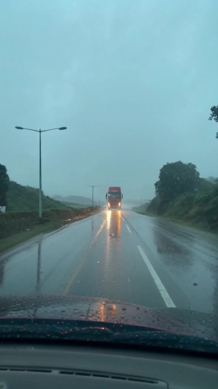 Descripcin visualCarretera solitaria cerca de IbaguLluvia intensa, todo est mojadoLa cmara se mueve lentamente por la va con faros de un camin al fondoTexto sugerido en pantalla opcionalIbagu, madrugada lluviosa