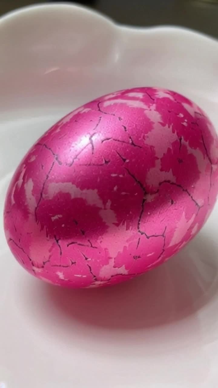 A pink camouflage Easter egg hatching 