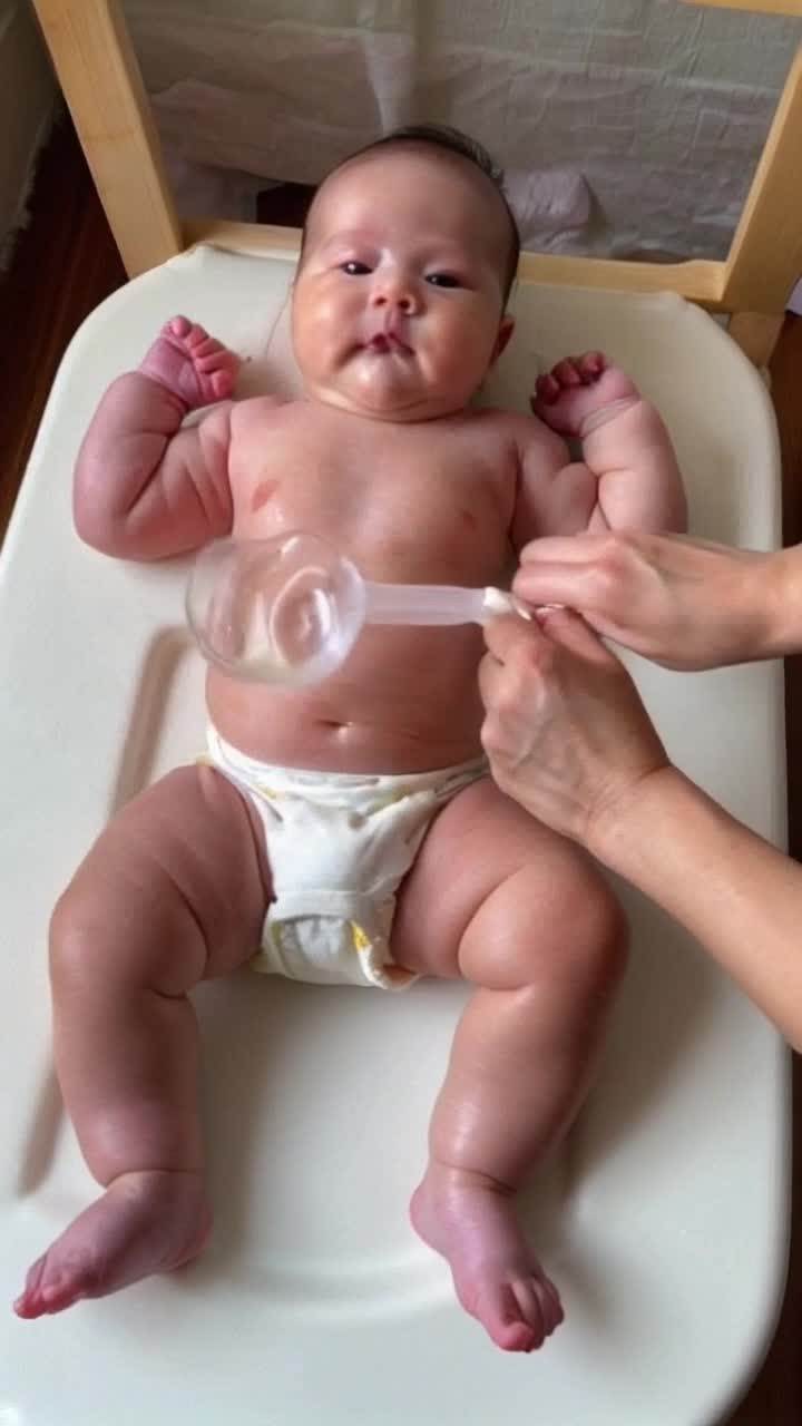 A mother putting her babymon its changing table and then getting a 6 inch enema and then getting water in the enema and then pushing it in her bottom just a little bit, then pushing it in and out and after a few minutes of that you put the enema all the in and then move it around 