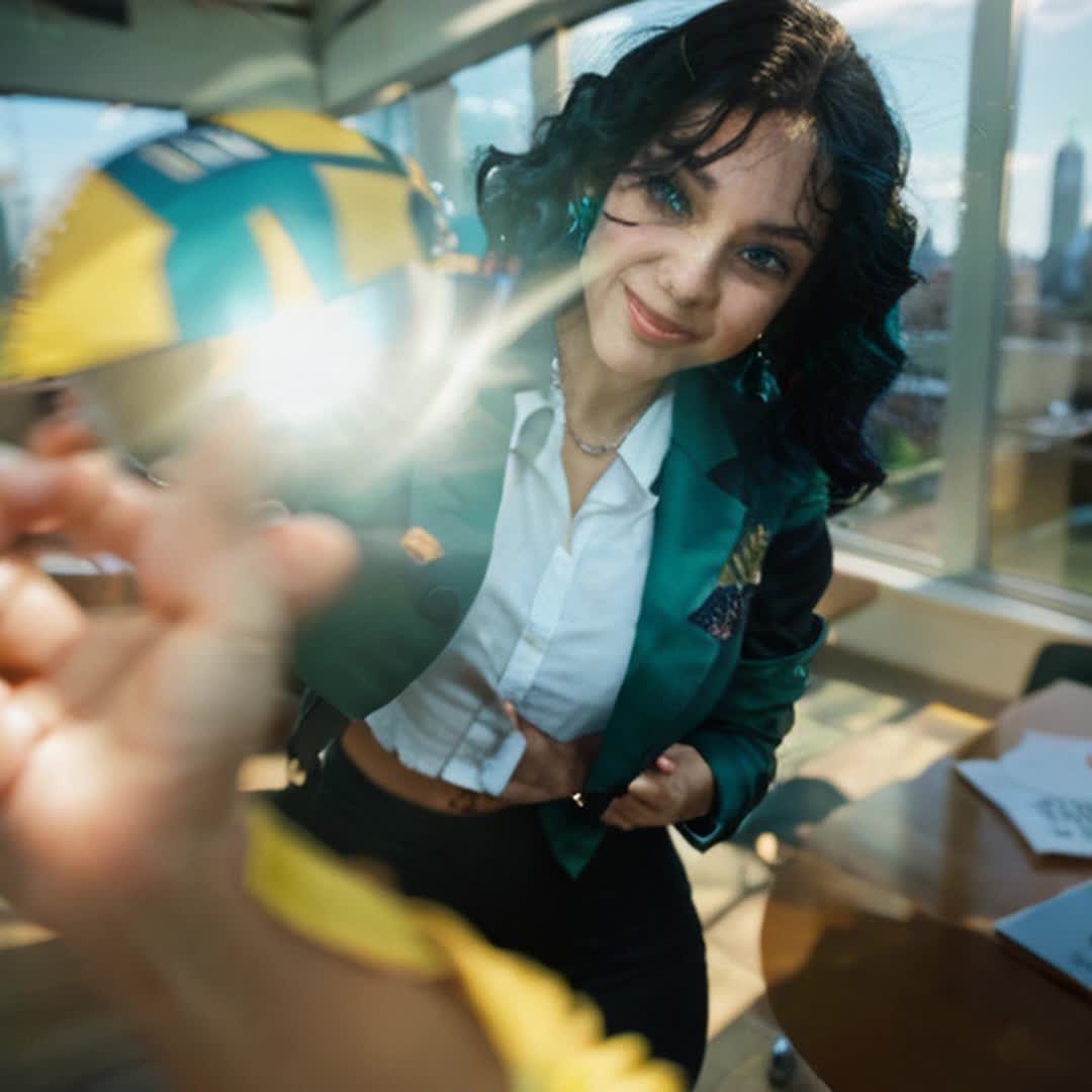Successful business leader, regal, confident, outgoing, positive demeanor, dressed in sharp, professional attire, standing in a modern office, large windows with city skyline, sunlight streaming through, interacting with team, engaging in discussion, gesturing confidently, motivational, dynamic energy, vibrant atmosphere, smooth camera movements, highdefinition details, cinematic feel, soft lighting and shadows, vibrant colors