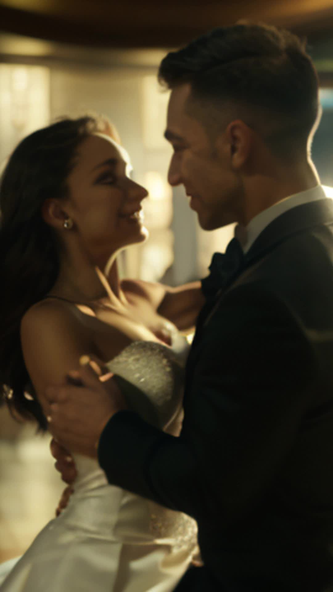 A couple dancing in a big empty room and as  the picture visual of the couple dancing zooms outward you see that they are in a diamond that a man older  , sitting next to wife is holding, background lighting footage raw, then realizing that the couple is looking into the diamond and seeing themselves from the past