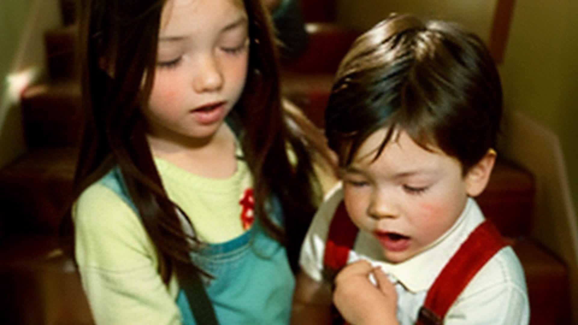 a little brunette girl and 2 brunette toddler boys on the staircase