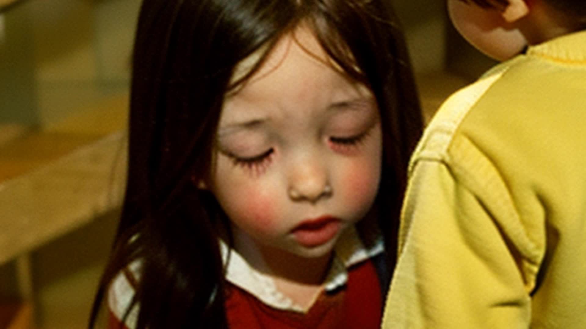 a little brunette girl and 2 brunette toddler boys spying from the staircase