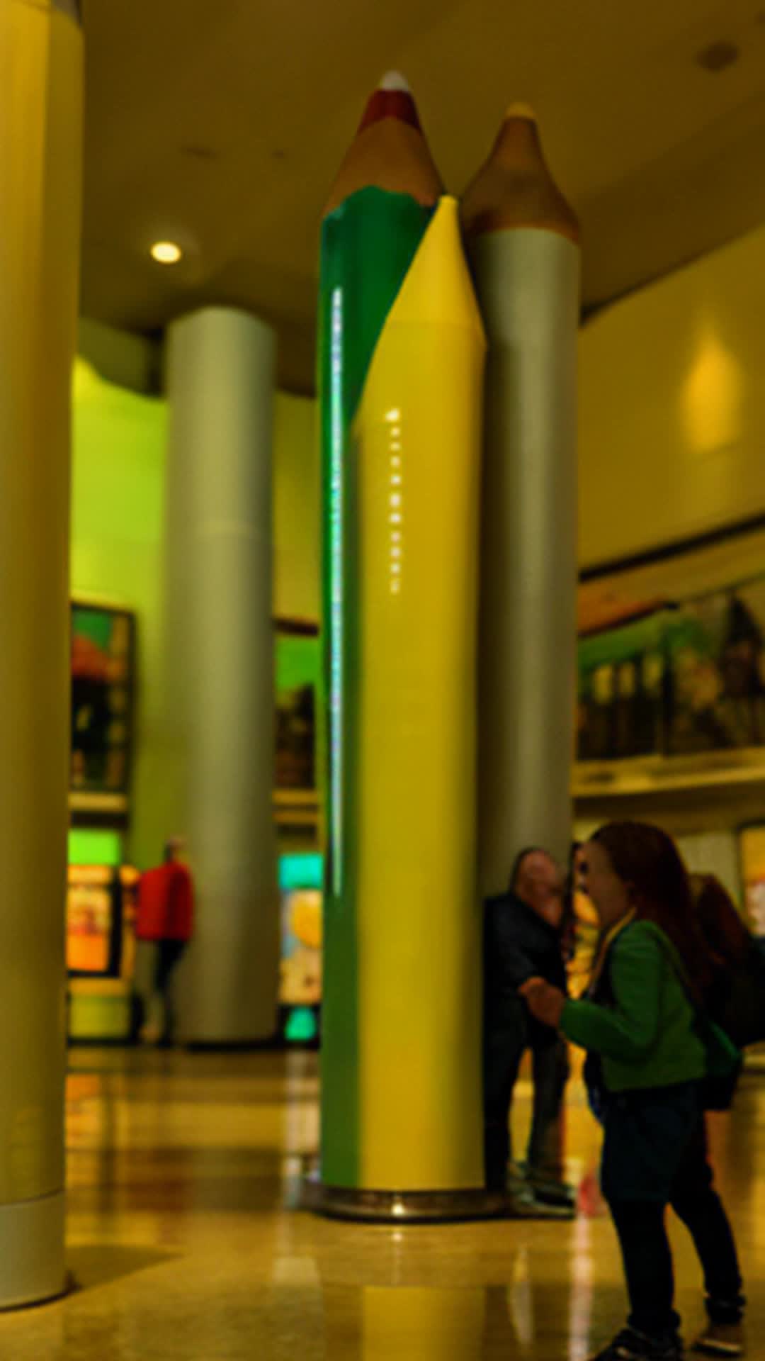 Giant 15-foot crayon by Crayola, Towering impressively, Wide angle, Spacious museum hall with curious visitors and informational displays