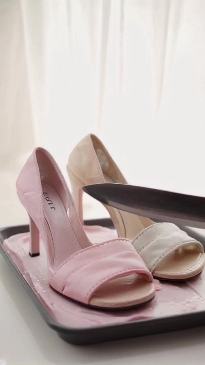 Soft rubbery heel sandals glistening in pastel pink and beige Smoothly sliced by a sharp heated knife on a pristin divided tray Background bathed in minimal soft light creating a calming ambiance highlighting sandals delicate colors Each slice produces gentle crunching and squishy ASMR sounds Slowmotion closeup shots reveal intricate inner textures Highdefinition visuals capture every detail creating a mesmerizing experience Soft ambient sounds combined with natural whispers enhance tranquility A subtle sparkle effect dances across the sandals surface adding a glossy allure captivating the viewers attention