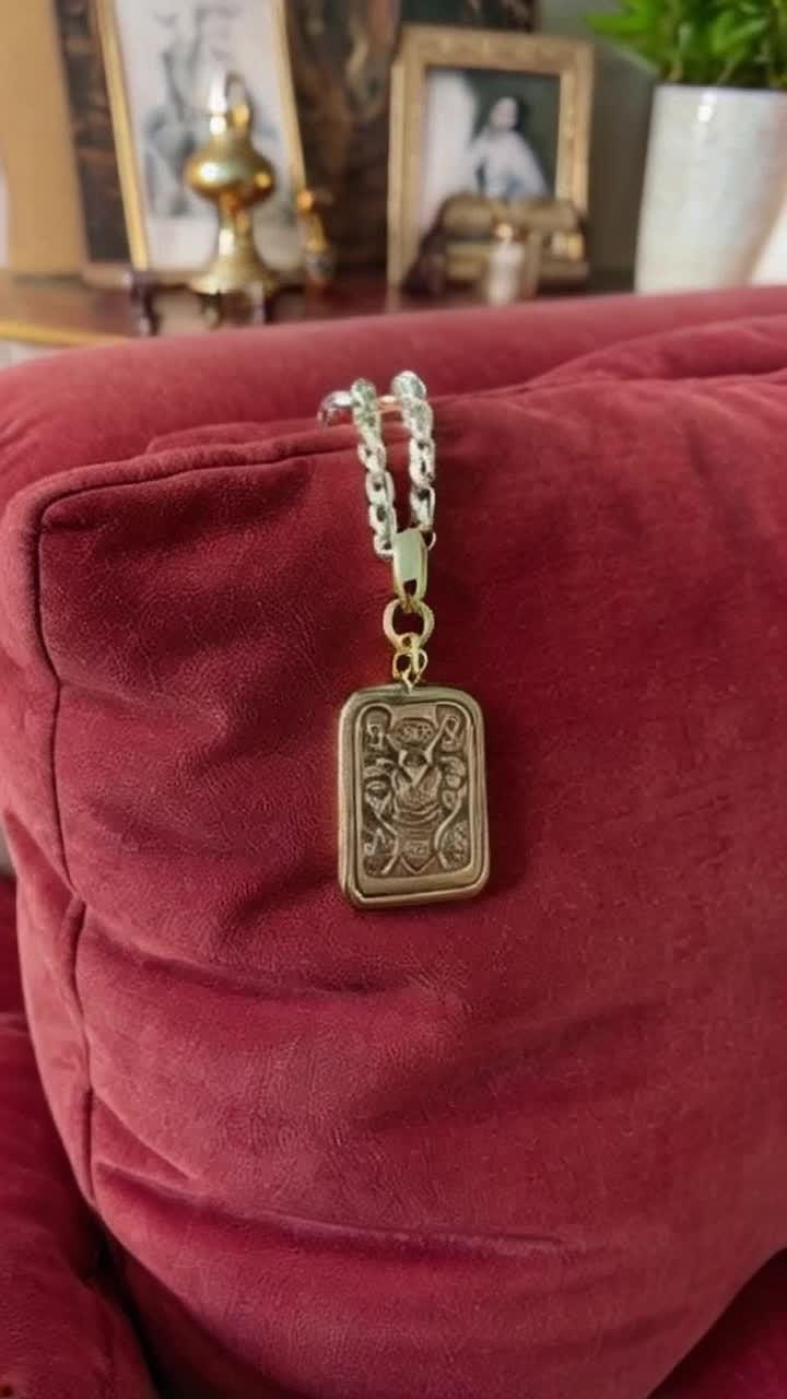 Glistening key chain adorned with intricate designs rests elegantly on plush velvet couch Soft light glimmers off metallic surfaces creating a dreamy atmosphere Surrounding decor features vintage accents and lush plant life enhancing the warm inviting scene