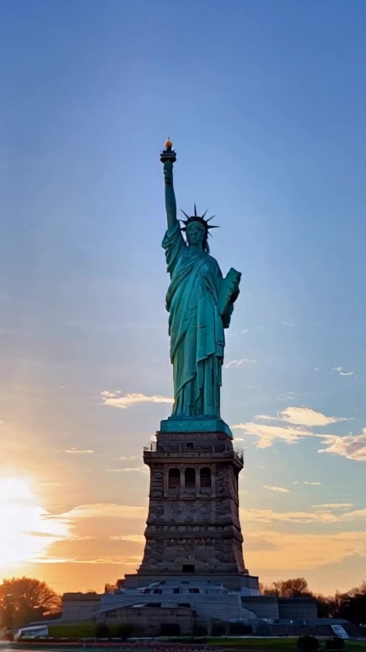 Beautiful Statue of Liberty with the world trade center towers in the background as a beautiful morning sunrise slowly rising