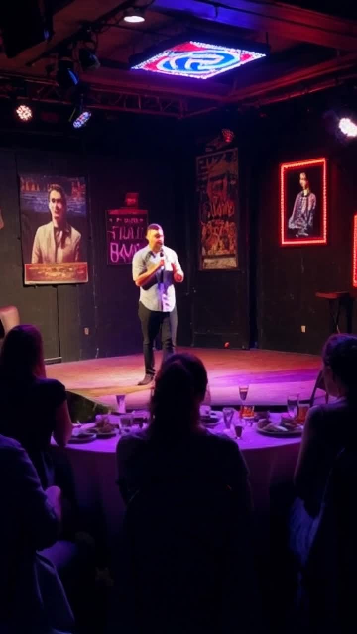 Nervous standup comedian clutching a microphone with shaky hands illuminated by a single spotlight on a small dimly lit stage filled with mismatched chairs and scattered empty glasses Fumbling through punchlines while adjusting an illfitting shirt revealing clear comic insecurity Small crowd sitting at round tables exchanging awkward glances and hesitant chuckles surrounded by peeling wallpaper adorned with old posters of iconic performers Vibrant neon sign flickers above boasting Open Mic Night contrasting with the quiet tension of anticipation in the air Walls echo with laughter from distant performers blending into a warm haze of potential connection
