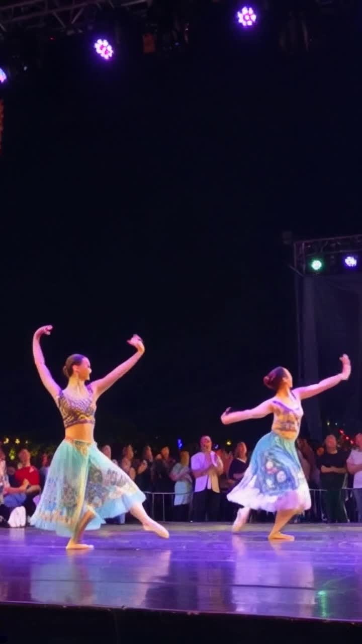 Colorful dancers twirl gracefully in vibrant costumes swirling fabrics with intricate patterns leaps into rhythm pulsating music fills the air electrifying energy ignites surrounding crowd dances along mesmerizing lights reflect off the stage as smiles light up faces joy radiates in every movement vibrancy of culture showcased through expressive choreography capturing tradition merging modern flair dynamic storytelling unfolds through powerful performances everyone lost in celebration of life and dance
