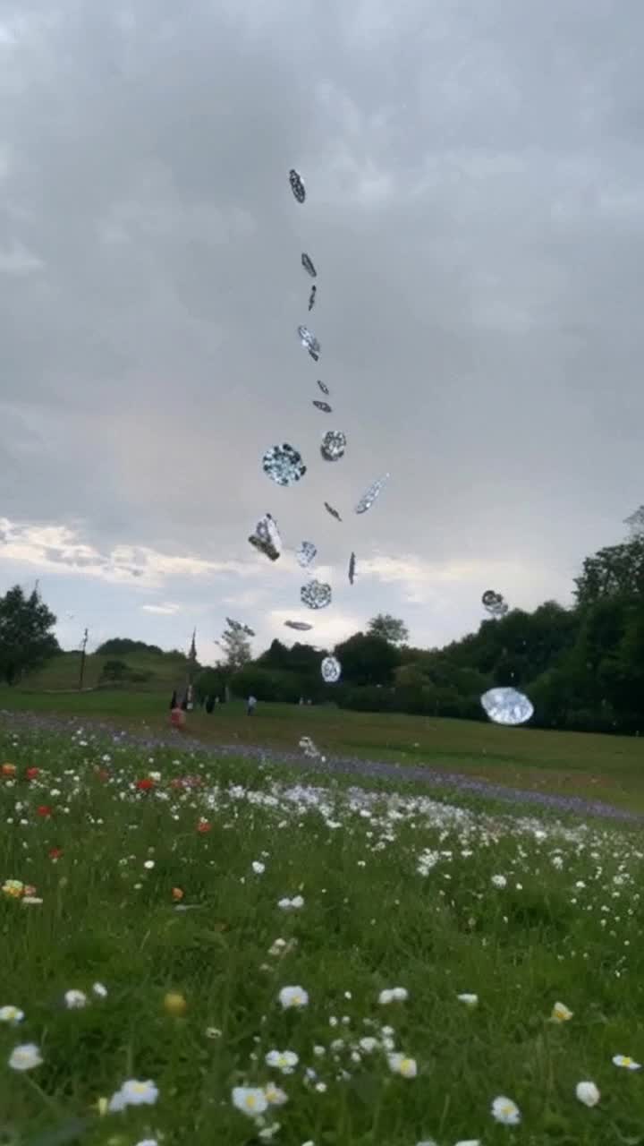 Diamonds raining from clouds in the sky onto a meadow