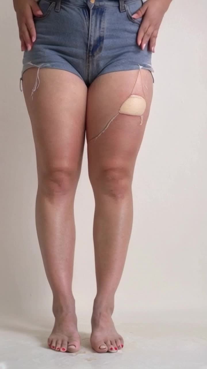 Realistic photograph of 1 woman, thick thighs, big camel toe, spread legs, see through shirt, short jeans, see through pants, ripped pants, ears down,  hands on stomach