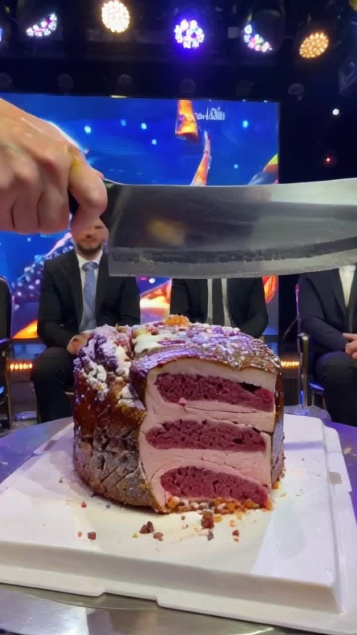 Glistening oversized steak knife slicing through a decadent cake designed to resemble a succulent steak Juicy layers revealed with each precise cut Brightly lit cooking competition stage adorned with glimmering lights and colorful decorations Three discerning judges watch intently from elegant chairs their expressions a mix of curiosity and delight