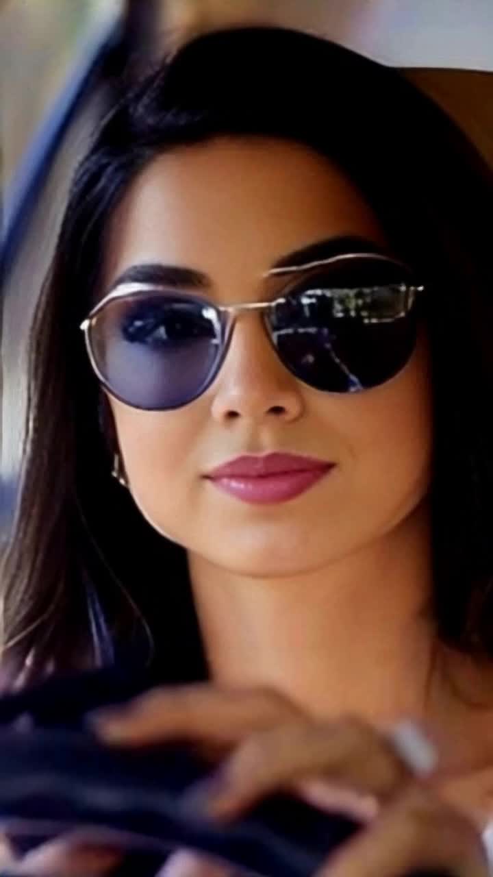 Stunning elegant woman radiating confidence in stylish sunglasses cruising effortlessly in a sleek convertible along a sunkissed coastal highway Wind tousles her hair while she smiles, savoring the freedom of the open road Vibrant blue ocean waves crash against rocky cliffs, shimmering under a clear azure sky Lush greenery lines the roadside, creating a picturesque backdrop of natures beauty Warm sunlight bathes the scene in golden hues, enhancing the sense of adventure and exhilaration as she speeds towards the horizon, embodying luxury and carefree spirit