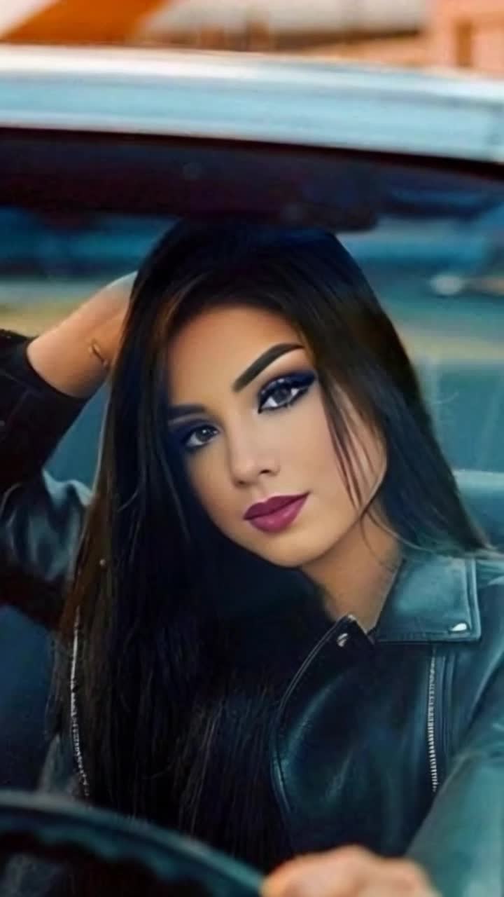 Radiant elegant woman with flowing hair cruising effortlessly in a sleek vintage convertible  Sunlight glinting off polished chrome creating a dazzling display as she smiles brightly  Vast open highway stretching towards a horizon painted with vibrant hues of sunset and lush greenery bordering the road