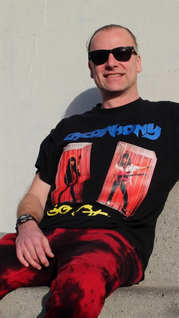 He sits there waving good bye and grinning, the tshirt he is wearing has full living animation, the white background is changed to a black hole, slowly being sucked into it