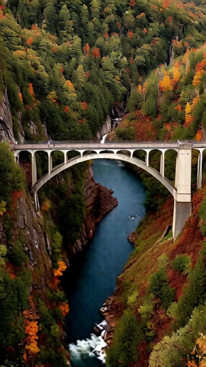 Majestic bridge arching gracefully over vibrant Appalachian mountains glistening in autumn hues of gold and crimson Water sparkling gently below as it dances over smooth stones Evergreen trees standing tall on rugged slopes capturing sunlight Soft rolling clouds drifting lazily across the bright blue sky creating a picturesque backdrop Natures symphony of rustling leaves and flowing water enhancing the tranquility of the scene