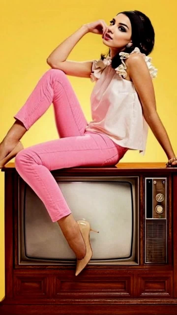 Elegant 60s woman exuding grace with flowing hair and vibrant vintage attire striking a pose atop a retro television glowing with nostalgic colors radiating warmth and charm surrounding her an eclectic room filled with midcentury decor soft sunlight filtering through sheer curtains casting a dreamy ambiance reflections dancing on polished surfaces inviting a sense of timeless beauty