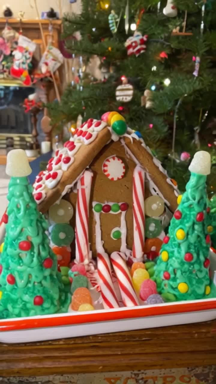 Gingerbread house with shimmering frosting candy accents Dreamily beckoning with warm glowing windows adorned with twinkling lights Delicate snowflakes drift in the night sky creating a tranquil atmosphere Pine trees dusted with fresh snow