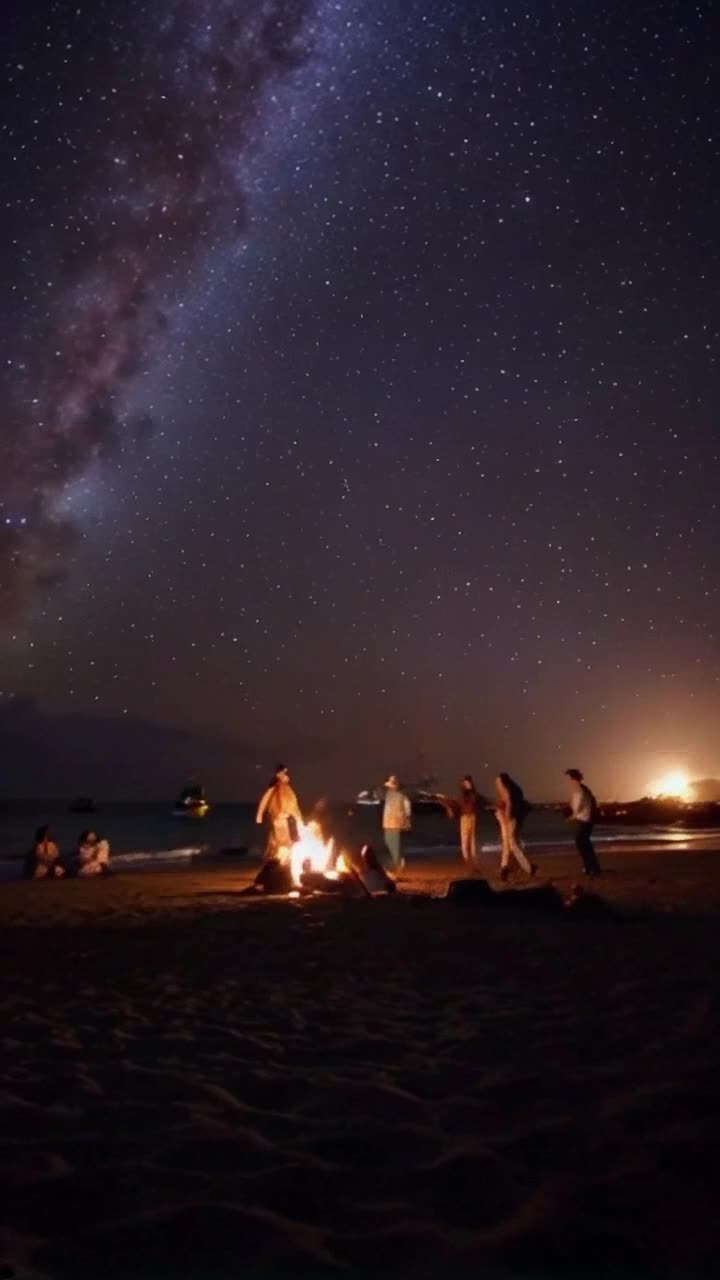 Elegant figures in cowboy attire swirl about on soft sandy shores illuminated by twinkling stars above rhythmic dance moves capturing joy and freedom Gentle waves lap against the beach as vibrant boats sail gracefully on the horizon under a canopy of silvery moonlight reflecting on the water creating a serene ambiance Flickering bonfires provide a warm glow casting playful shadows on smiling faces as laughter mingles with the sounds of the ocean enhancing a picturesque evening celebration under the mesmerizing night sky filled with sparkling constellations
